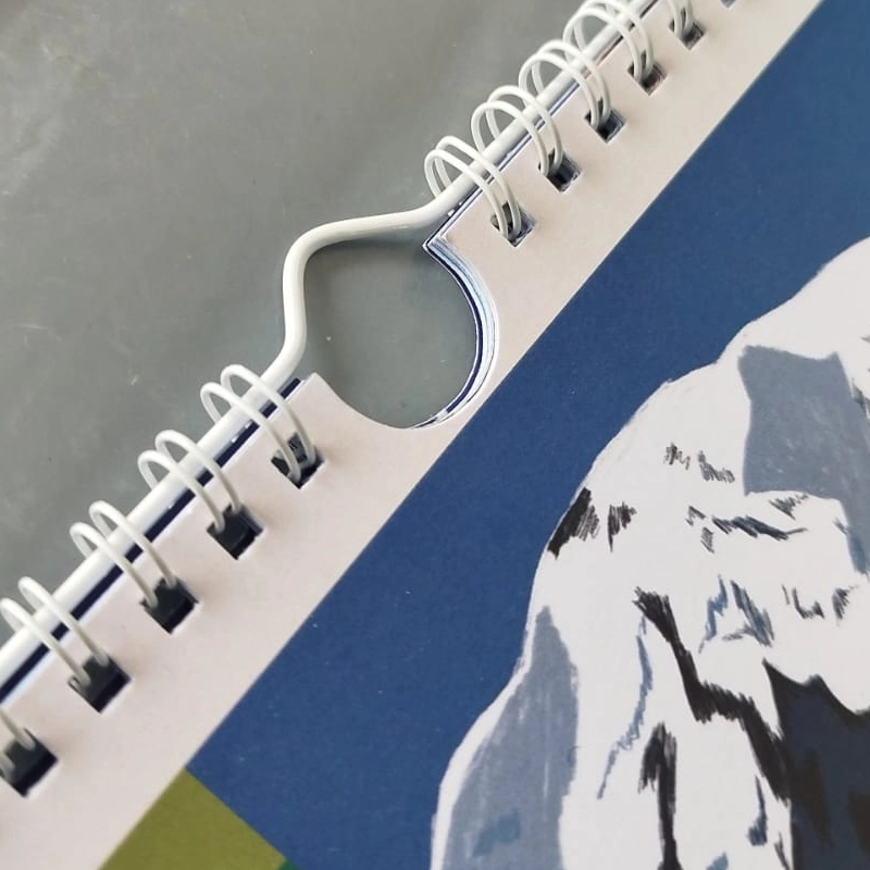 Detalle de anillado doble O metálico para calendarios y agendas personalizadas en Bogotá.